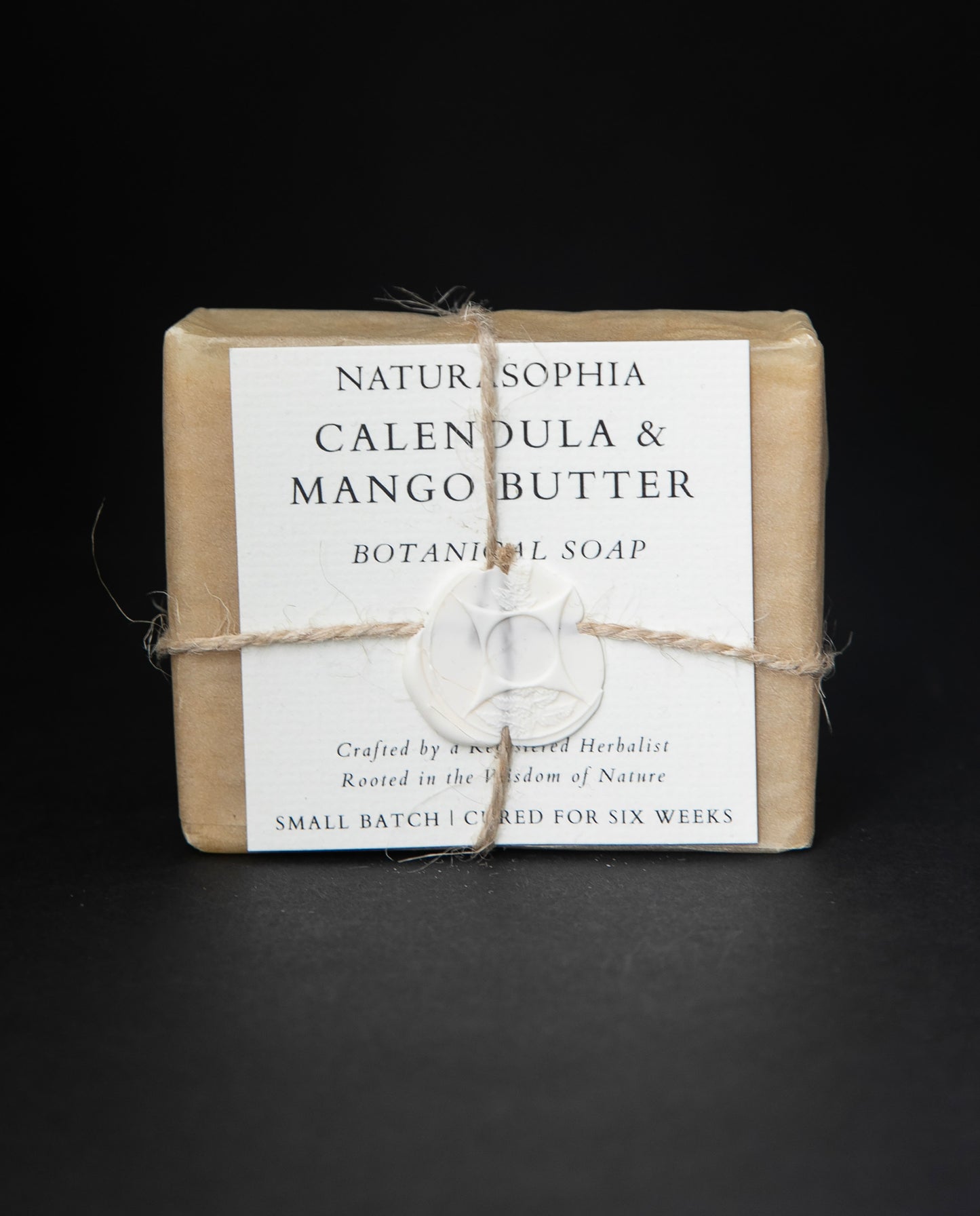 Bar of Naturasophia soap wrapped in brown paper and twine, with a label that reads