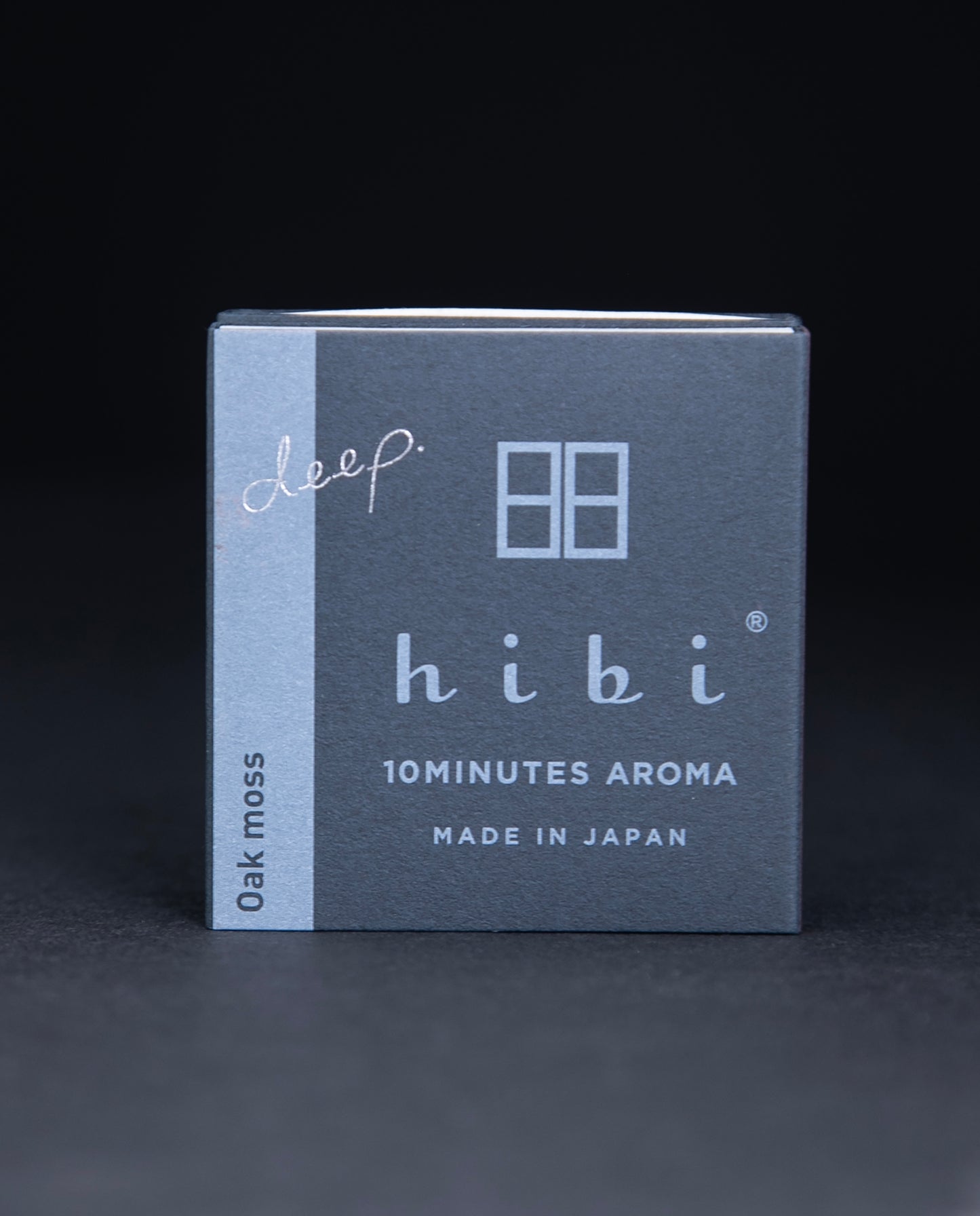 Dark slate grey paper box containing HIBI