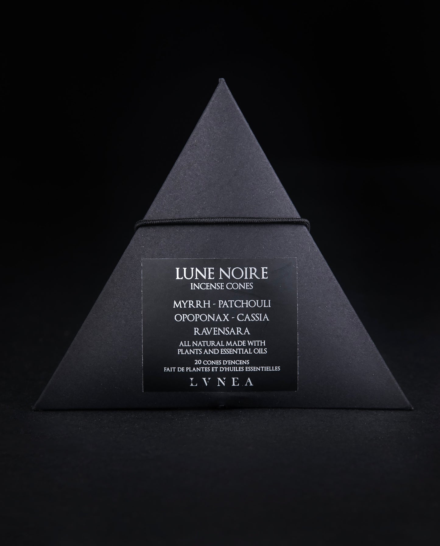A closed black paper pyramid box of LVNEA's 'Lune Noire' incense. The black label on the box reads
