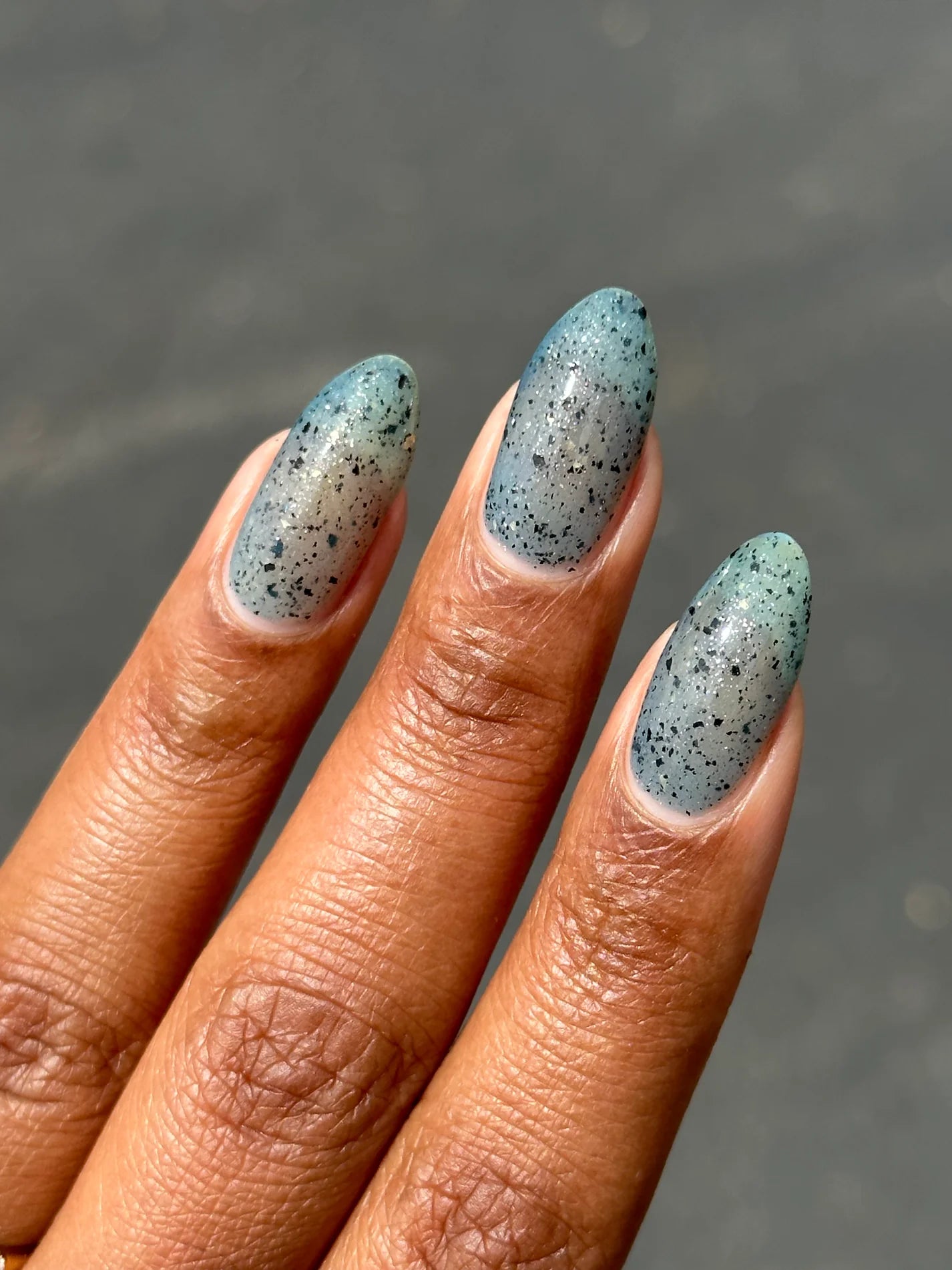 Close up of nails with blue speckled polish