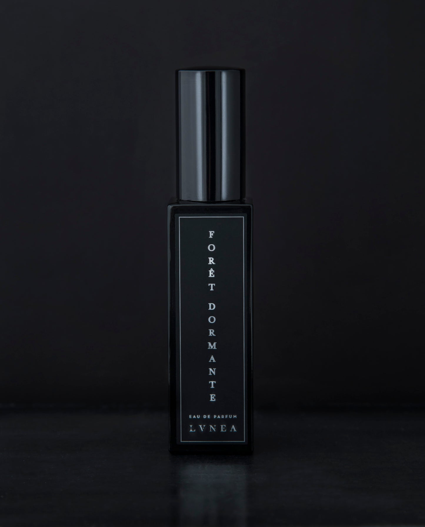 30ml black glass bottle of LVNEA’s Forêt Dormante natural perfume on black background