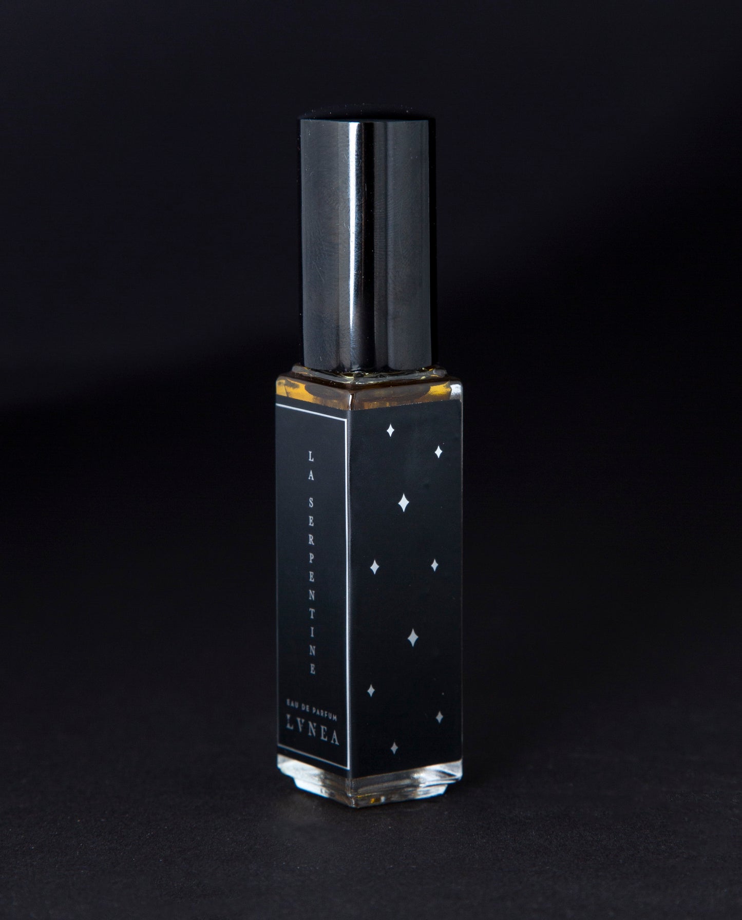 A fruity, leathery, unisex chypre fragrance by natural and botanical perfume brand LVNEA with notes of peach, osmanthus, patchouli, labdanum, and oakmoss. Presented in a 8ml star-spangled black glass bottle, the label reads LA SERPENTINE EAU DE PARFUM.