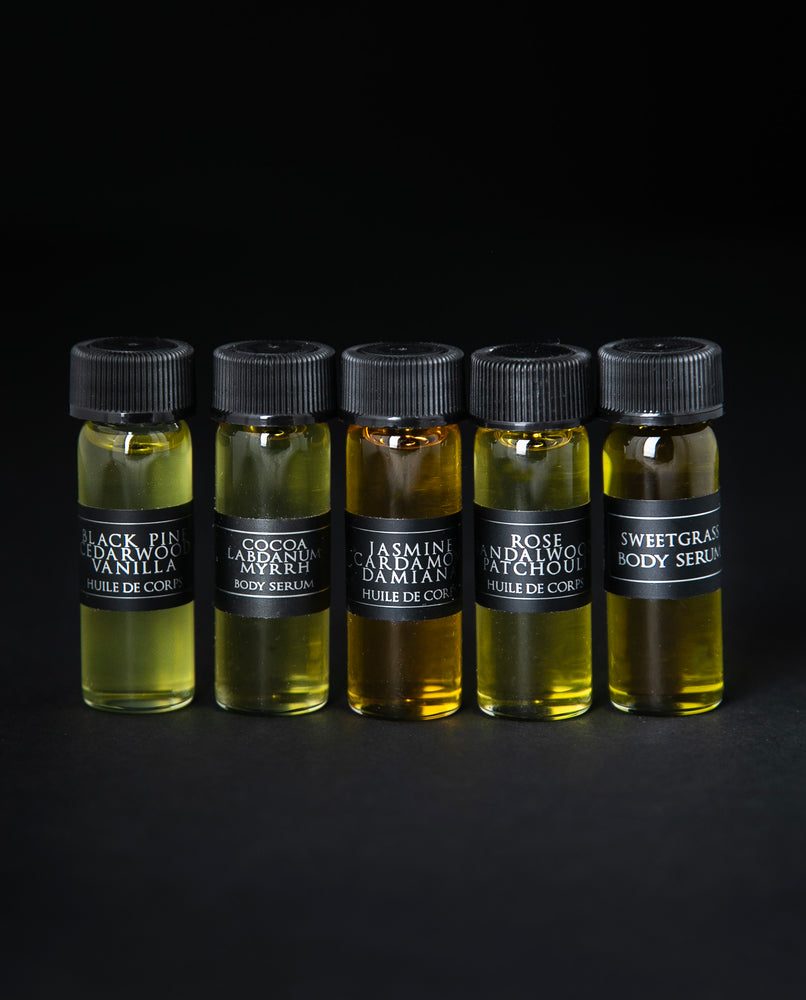 4ml glass sample vials of each of LVNEA's five body serums. They are lined up next to each other on a black background