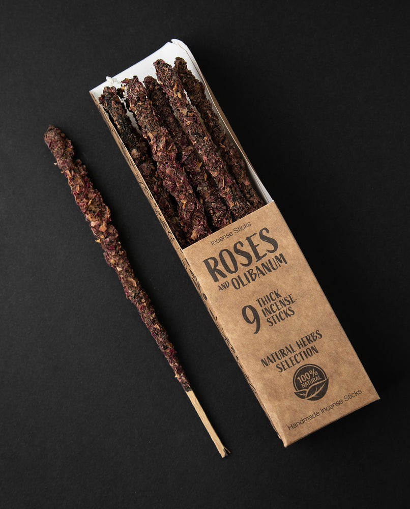 Open box of Rose and Olibanum incense sticks, 1 stick is removed and sitting next to the box.
