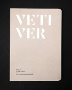 The book "Vetiver in Perfumery" on a black background. The cover is a light tan colour and reads "VETIVER" in bold white graphic letters.