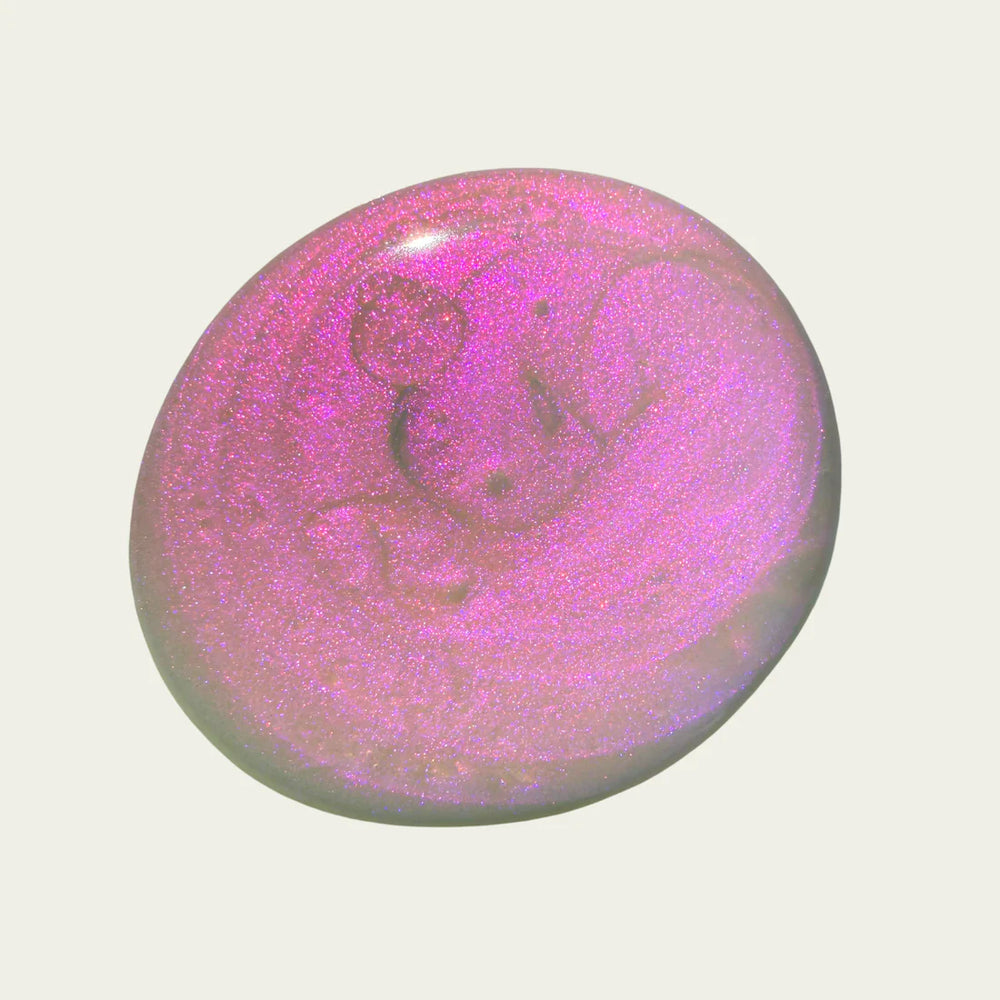 Pink and purple glittery nail polish swatch on a white background