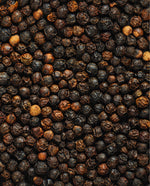 a sea of dried black peppercorns seen from a graphic overhead angle