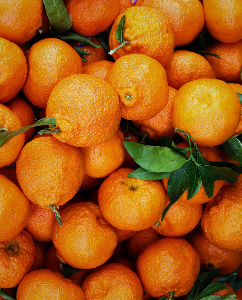 mandarin oranges with stems attached taking up the full frame