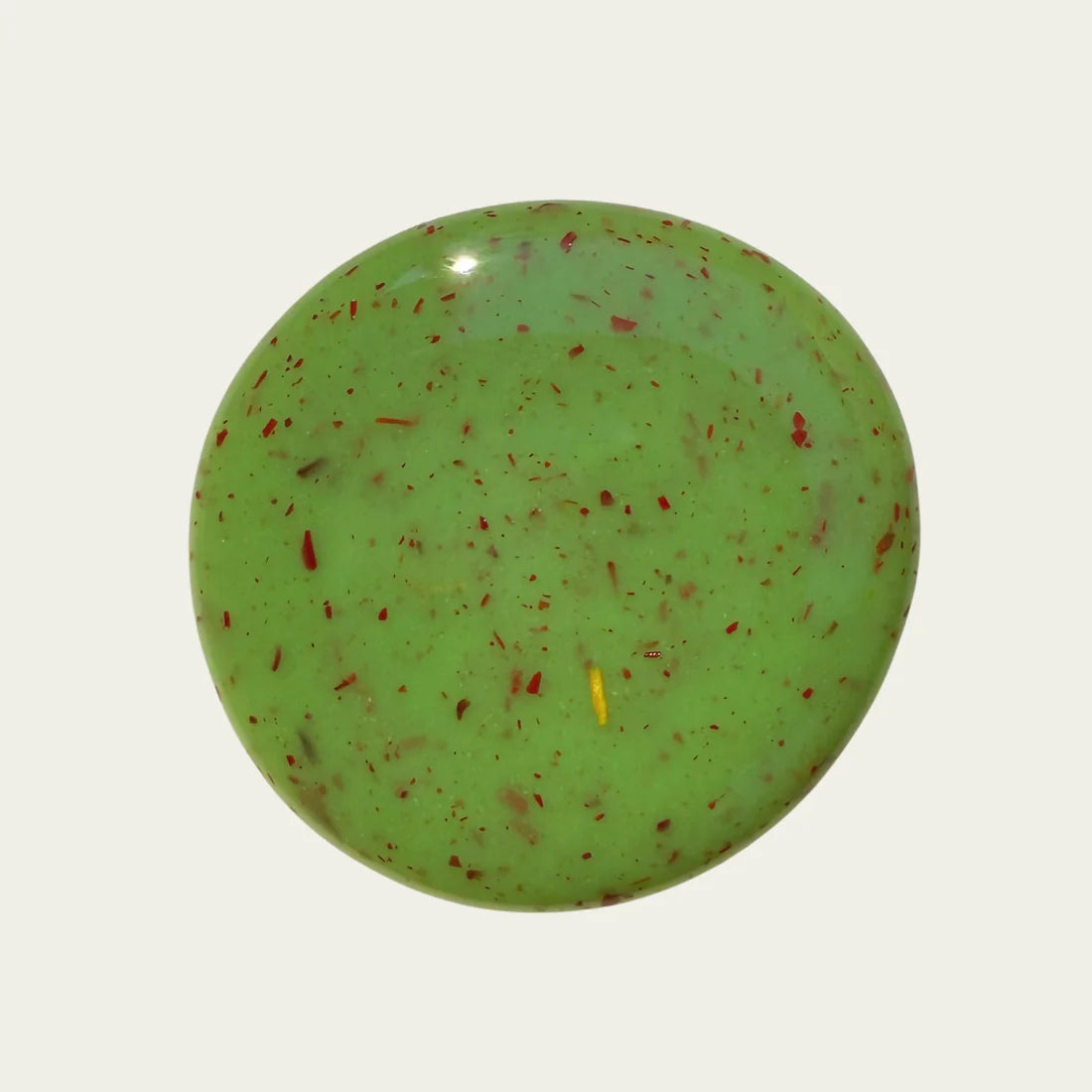 Green polish with red speckles on a white background