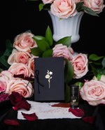 LVNEA's "Bleeding Hearts" scented stationery set surrounded by roses and milk glass.