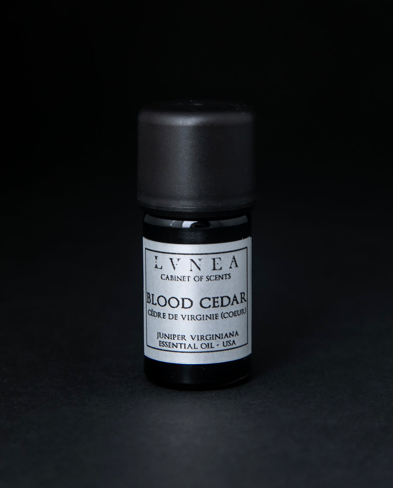 5ml black glass bottle with silver label of LVNEA's blood cedar essential oil on black background