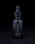 1oz amber glass bottle with dropper top and black label, containing Rown + Sage's "Dark Days" tincture on black background.