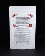 Backside of a white 50g pouch of "The Ecstasy of Mary Magdalene" herbal tea against black background. There are illustrations of roses pictures.