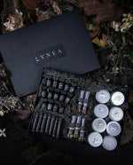 Sample set of LVNEA's entire signature line of perfumes in a black moss-ladden box, sitting on a bed of dead leaves and dried botanicals.