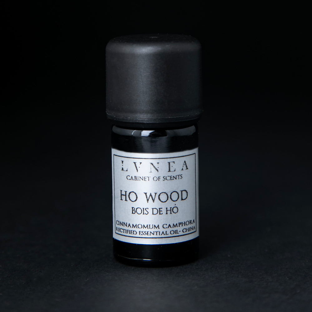 5ml black glass bottle of LVNEA's ho wood essential oil on black background. The label on the bottle is silver.