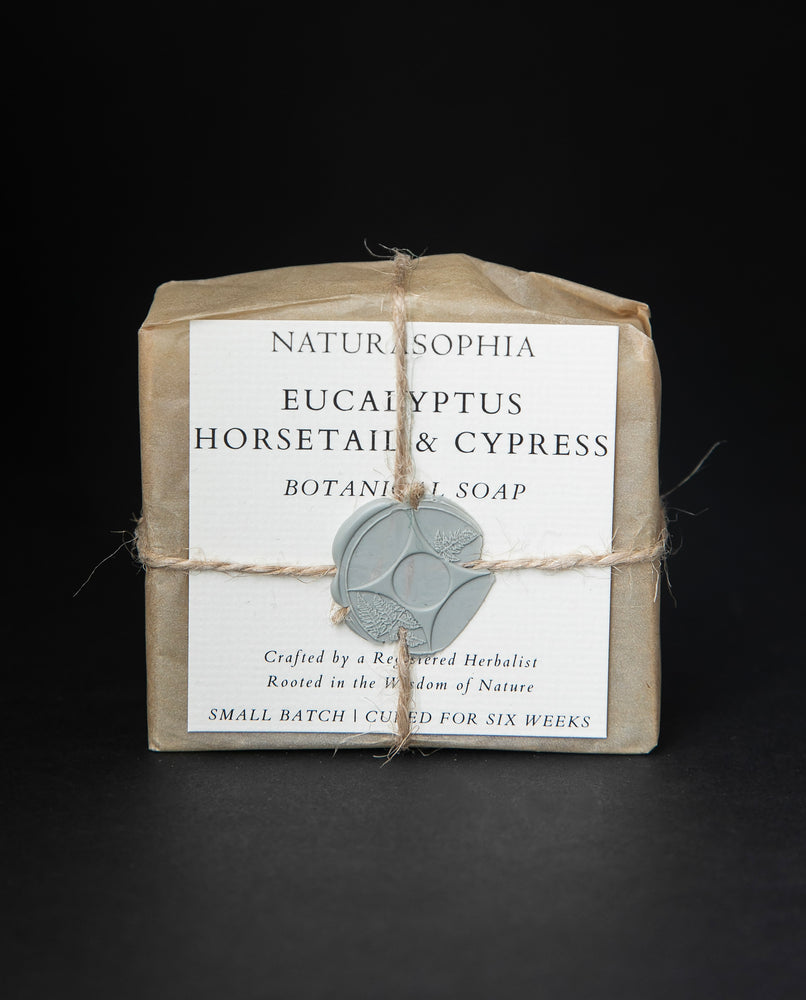 Bar of Naturasophia soap wrapped in brown paper and twine, with a label that reads "Eucalyptus, Horsetail & Cypress". There is a blueish grey wax stamp holding the label in place.