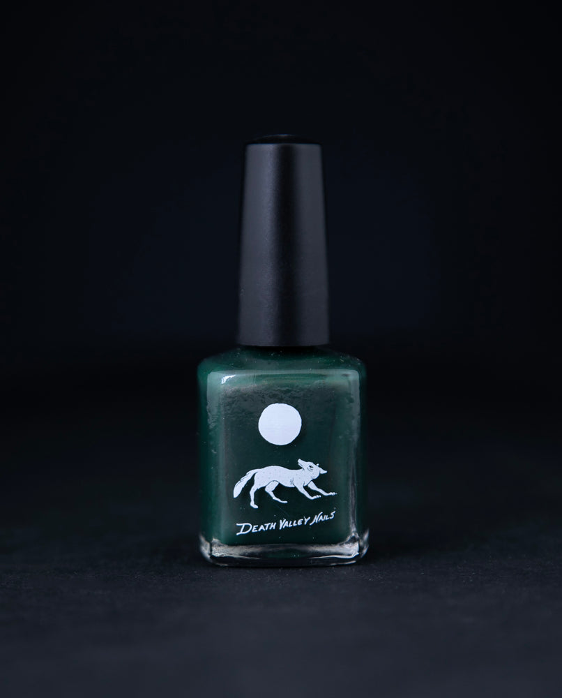 "Lone Pine" nail polish by Death Valley Nails on black background. The polish is forest green with a subtle copper shimmer.