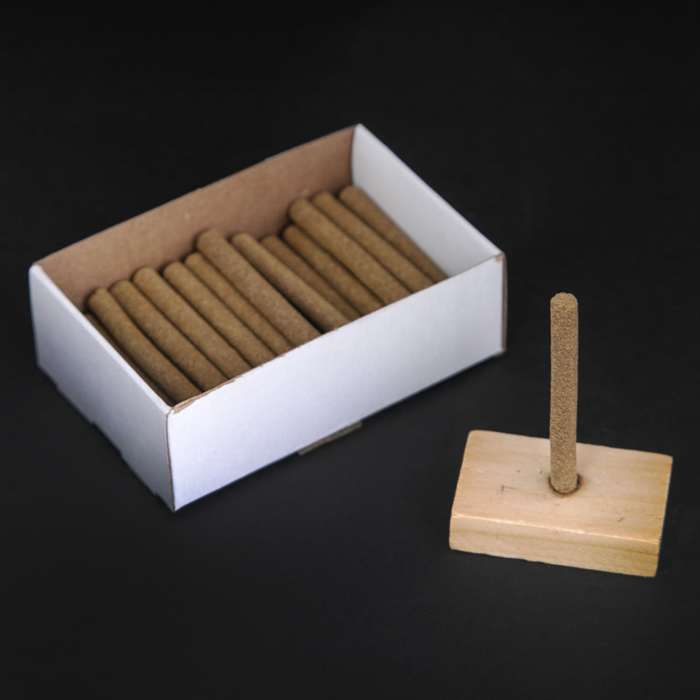 Open box of Paine's Balsam Fir incense logs on black background