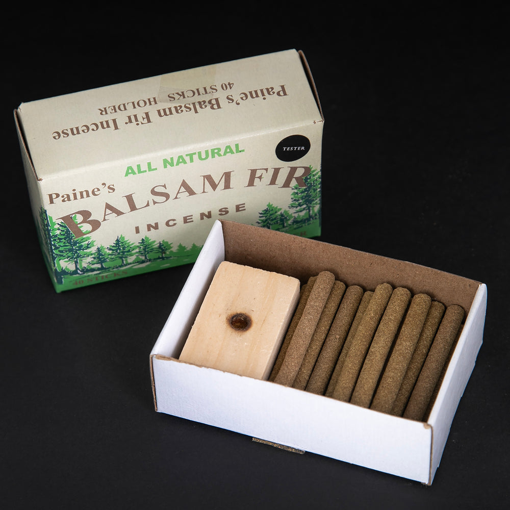 Open box of Paine's Balsam Fir incense logs on black background