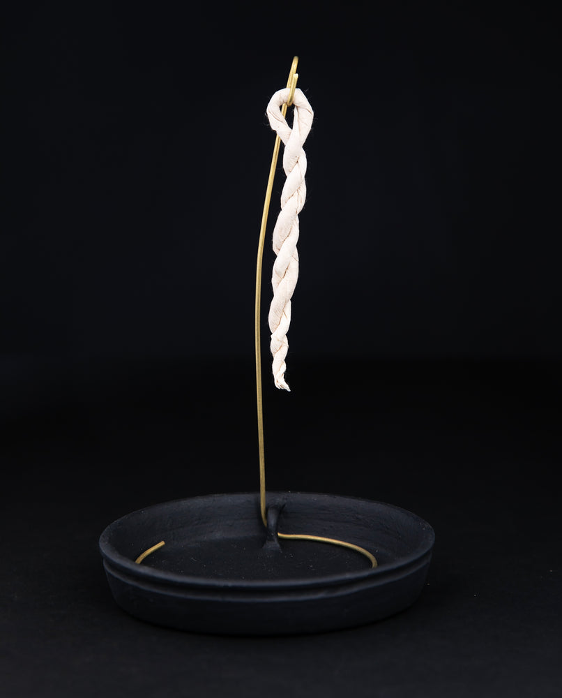 Rope incense holder with black ceramic base plate and brass hook on which to hang rope incense