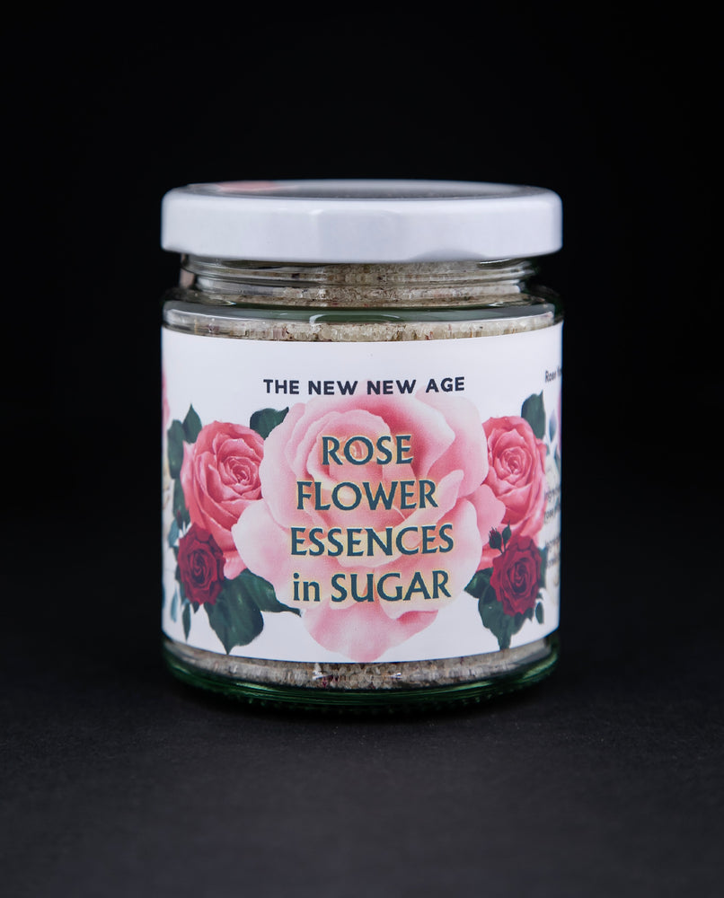 130g clear glass jar of The New New Age's "Rose Flower Essences in Sugar". There are illustrations of roses on the label.