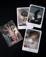 Overhead shot of The Seashell Oracle Deck booklet and 3 of its cards, each featuring collages of vintage illustrations, scattered on a black surface.