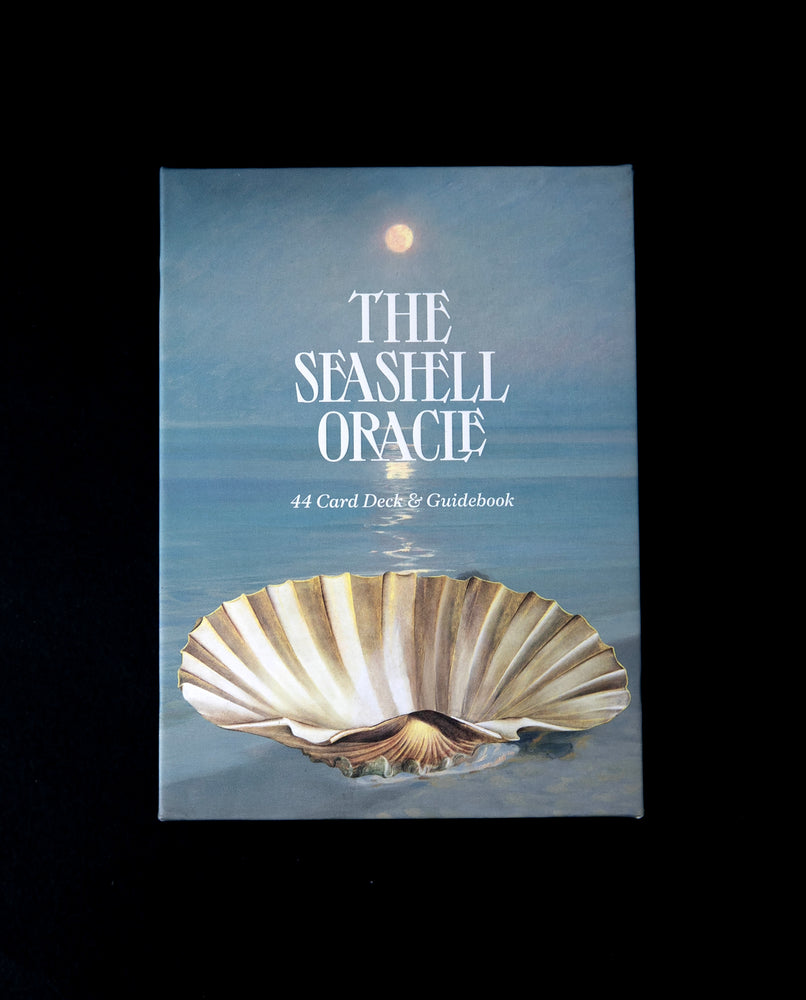 Cover box of The Seashell Oracle. The illustration on the box depicts a white shell sitting atop tranquil waters at night, with the moon glowing above it.
