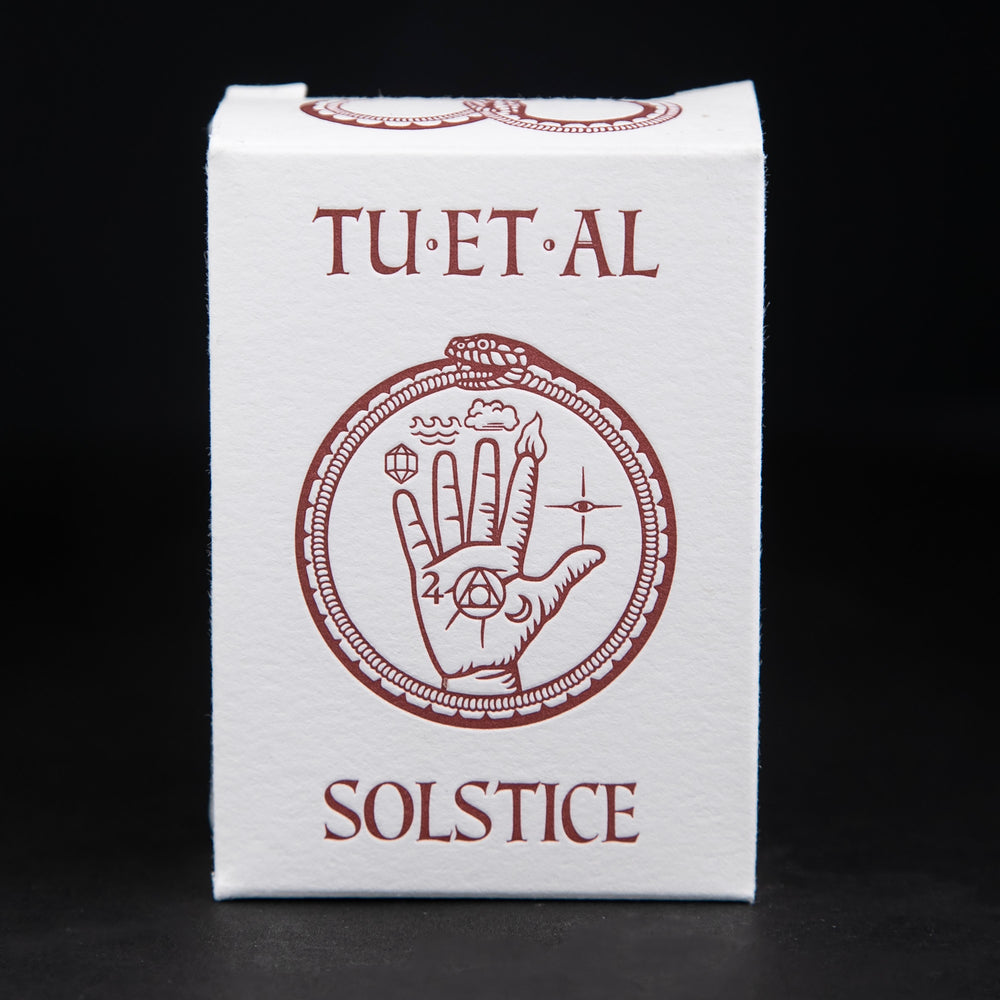 
                      
                        White cardboard soap box containing TU-ET-AL's "Solstice" soap. There is an illustration of a snake eating it's own tail, and an alchemical hand on front in brown.
                      
                    