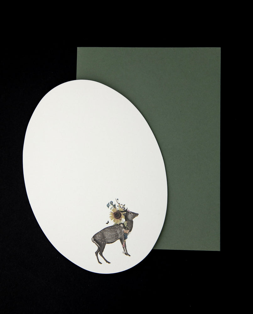 oval shaped card sitting atop a green enveloppe