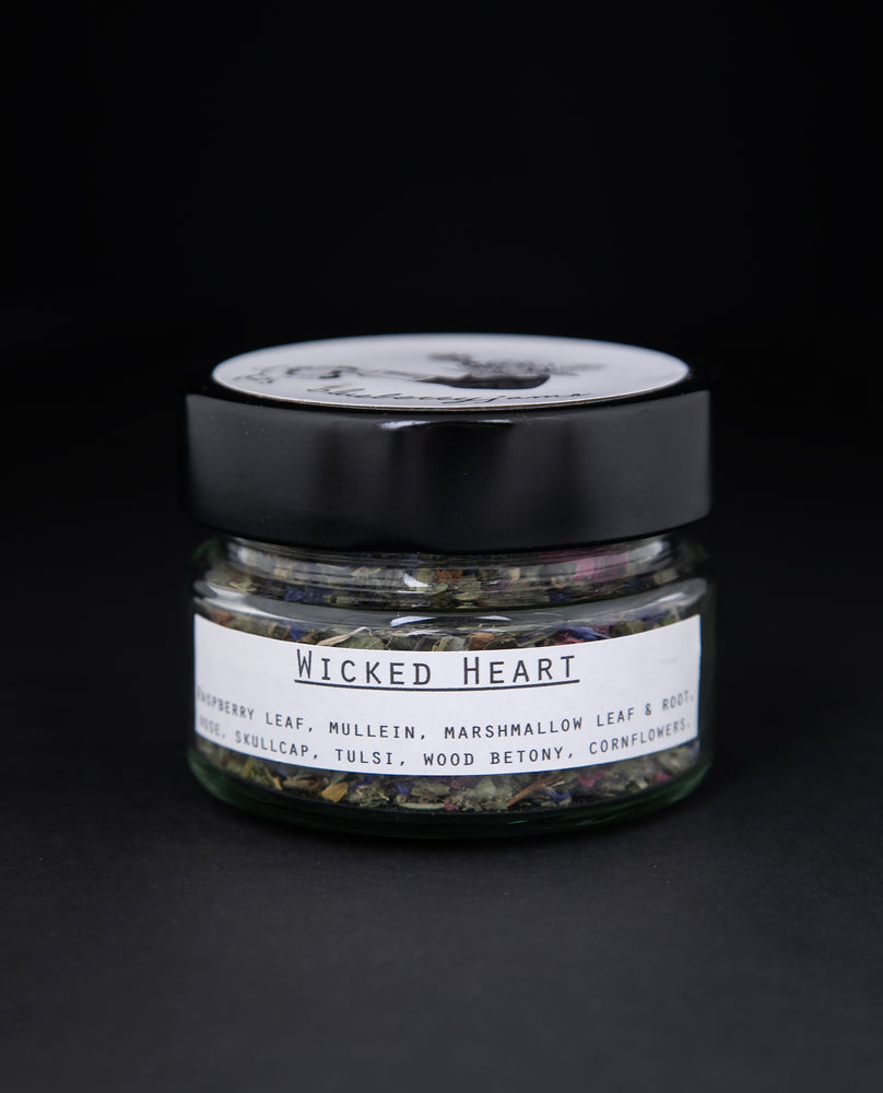 Clear glass jar of Blueberryjams' "Wicked Hearts" rolling blend against of black background