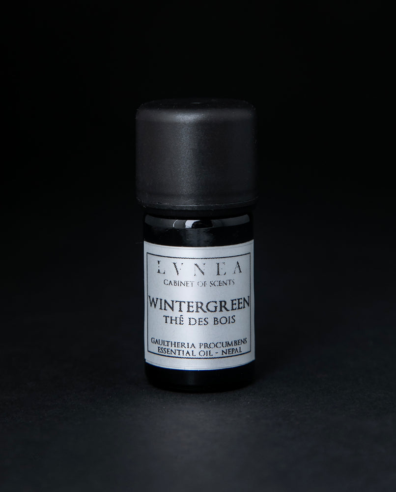 5ml black glass bottle of LVNEA's wintergreen essential oil on black background. The label on the bottle is silver.