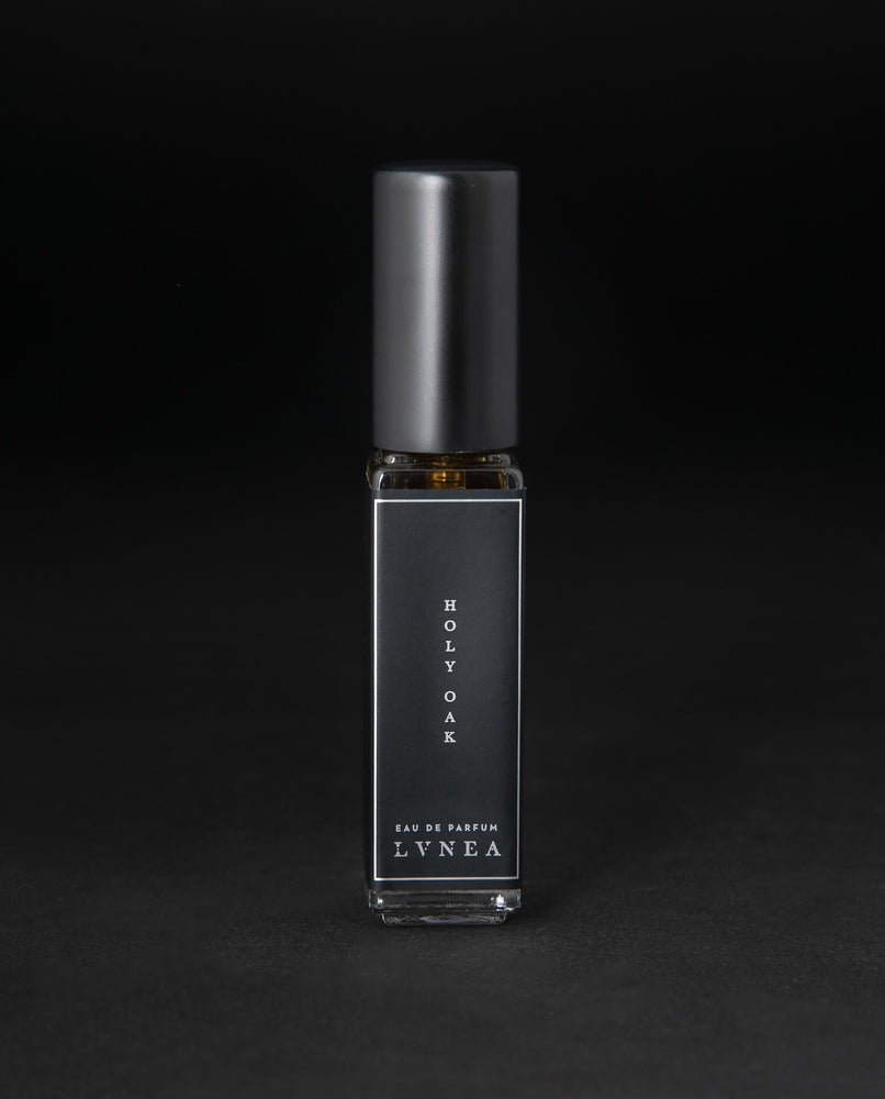 8ml clear glass bottle of LVNEA’s Holy Oak natural perfume on black background