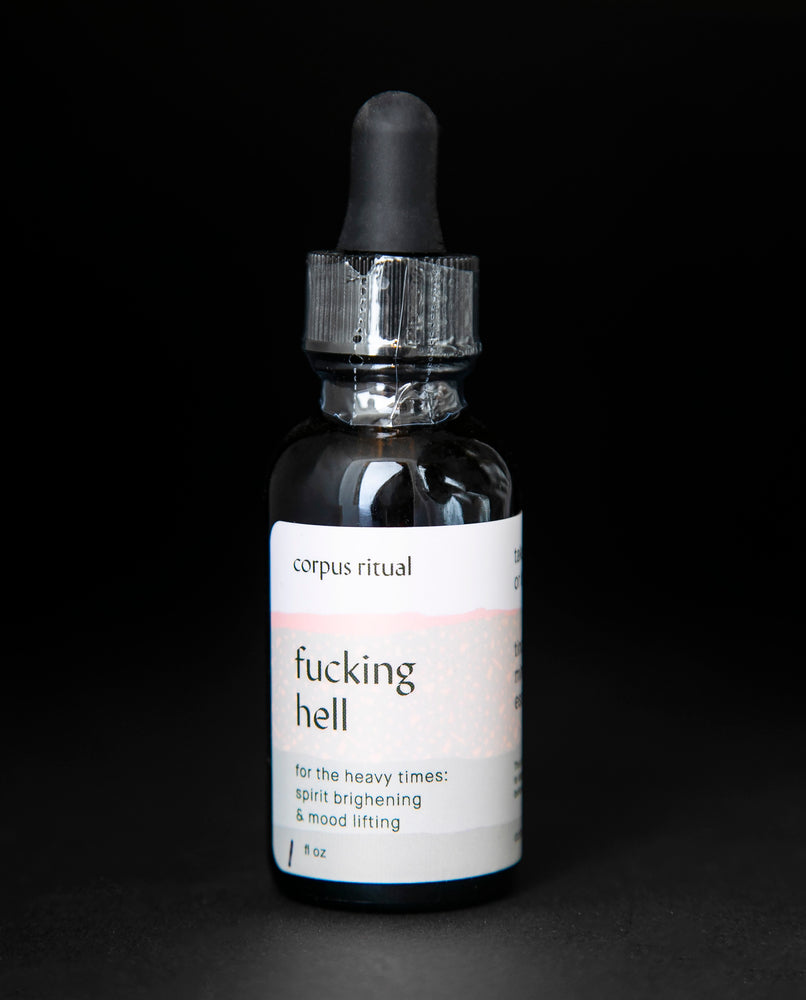 black glass bottle with dropper top on black background. The bottle contains Corpus Ritual's "fucking hell" herbal tincture