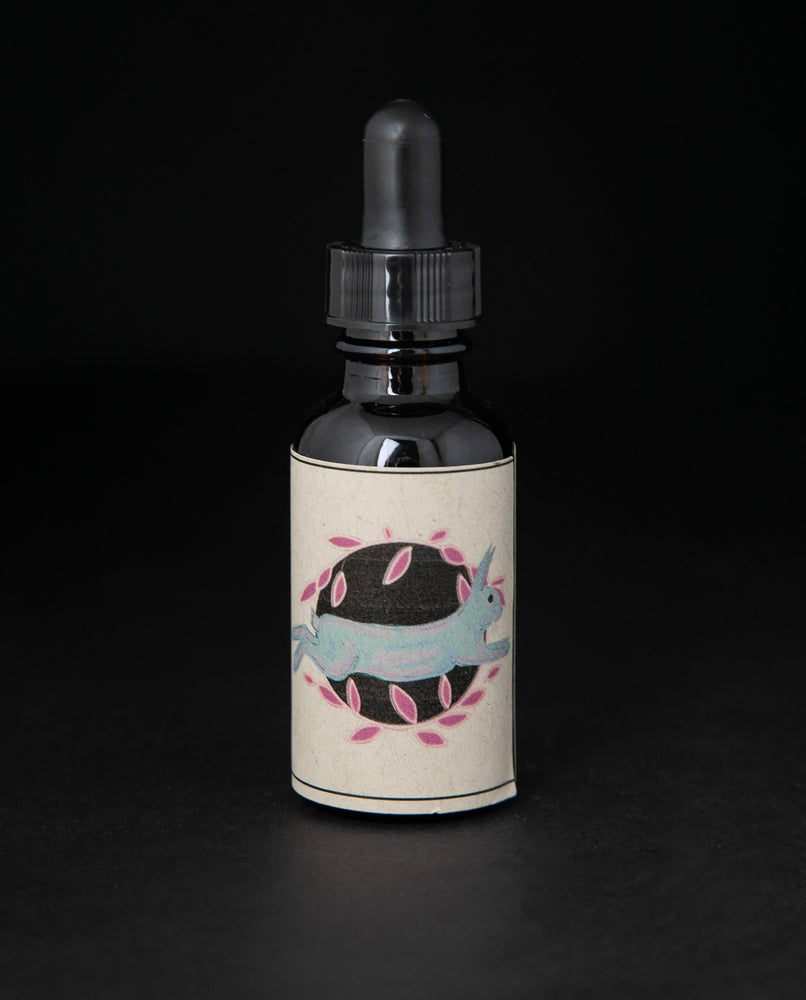 Black glass bottle with dropper top and tan label featuring an illustration of a rabbit. the bottle contains a herbal tincture by blueberryjams.