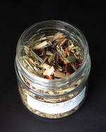 Open jar of blueberryams' "Alight in the Dark" herbal tea. Whole cardamom pods and other botanical ingredients are visible.