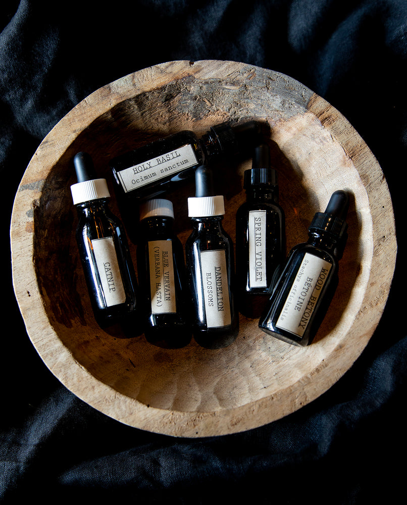Wooden bowl filled with 6 assorted bottles of blueberryjams' single origin herbal tinctures.