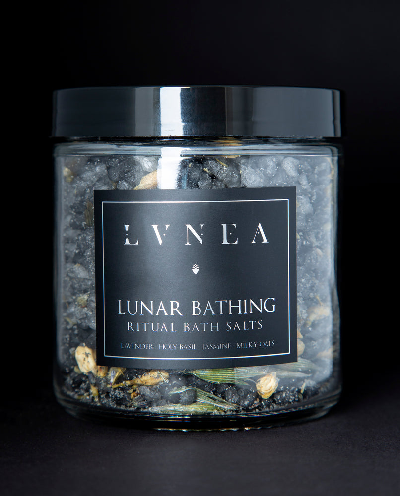 A clear 16 ounce jar filled with LVNEA's Lunar Bathing bath salts on black background