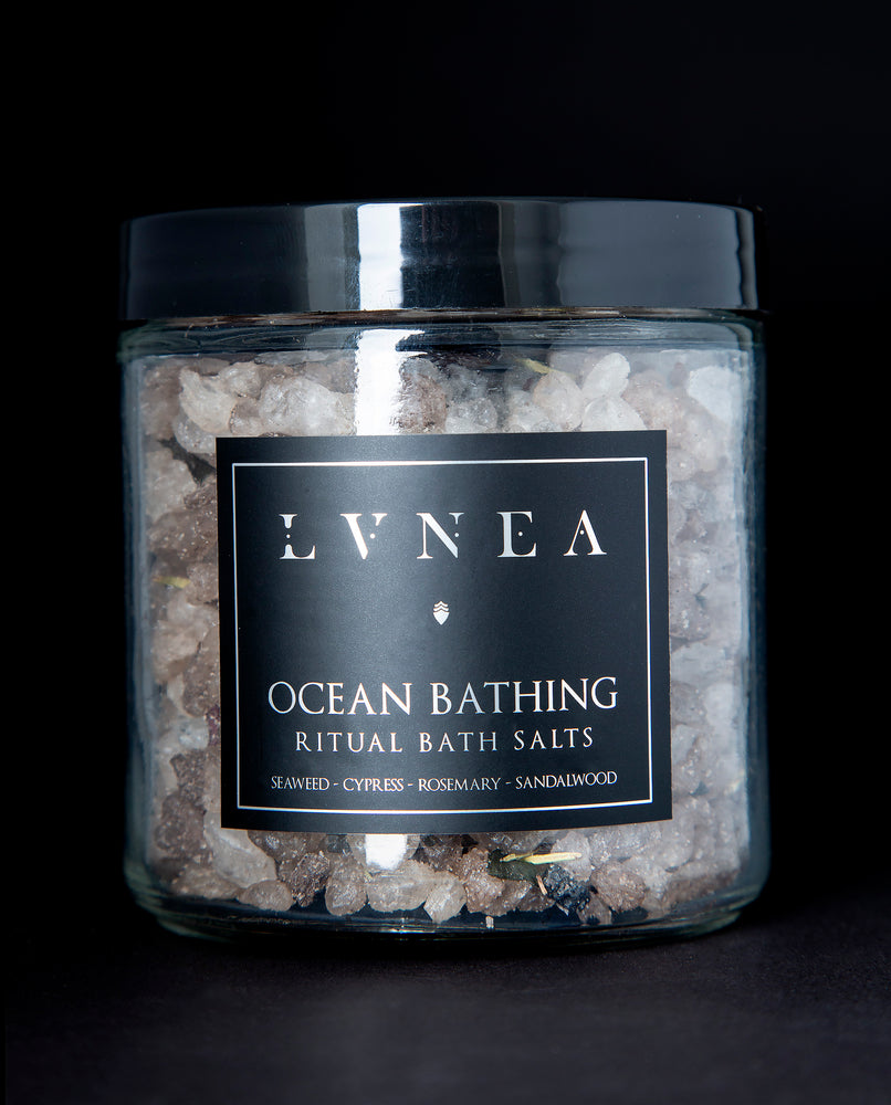 A clear 16 ounce jar filled with LVNEA's Ocean Bathing bath salts on black background