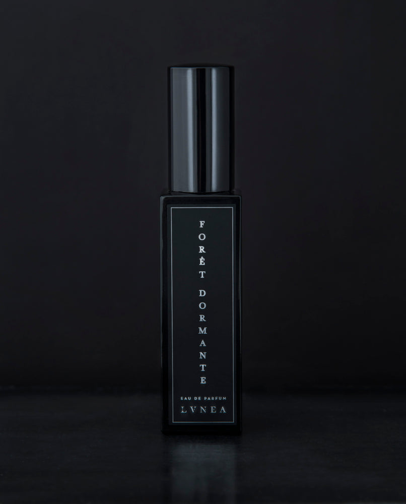 30ml black glass bottle of LVNEA’s Forêt Dormante natural perfume on black background