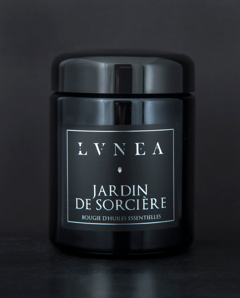 LVNEA’s Jardin de Sorcière candle housed in a resealable 8 ounce black glass jar on a black background