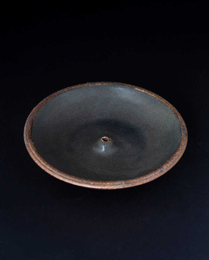 matte black glazed stoneware incense holder on black background