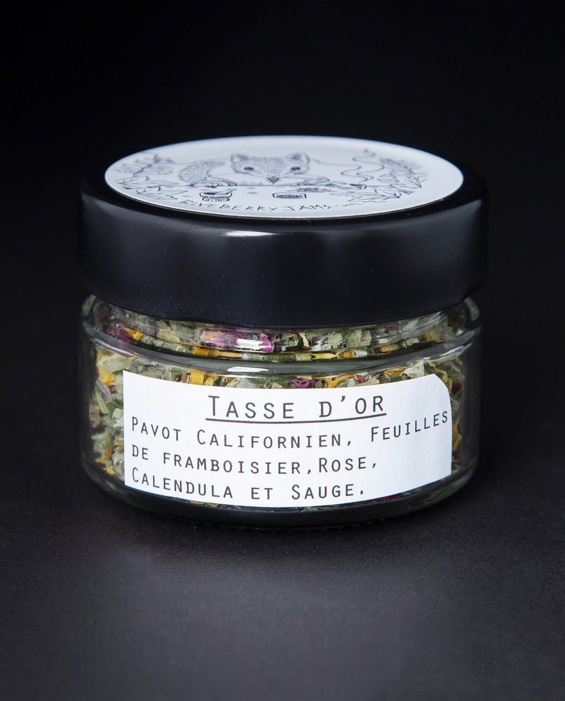 Clear glass jar with black lid containing blueberryjams' "Cup of Gold" rolling blend. French label reading "Tasse d'Or" is visible.