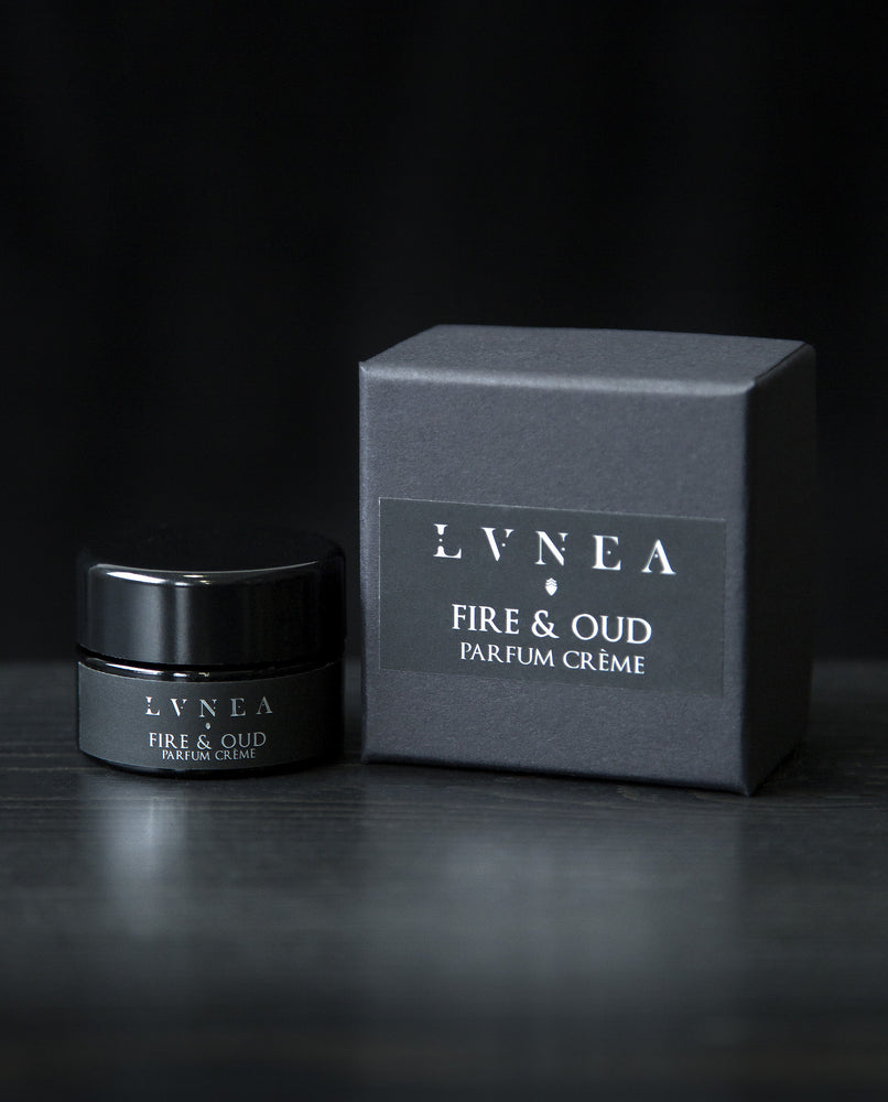 10g black glass jar of LVNEA's Fire & Oud solid perfume and its box on black background