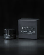 10g black glass jar of LVNEA's Hemlock Shade solid perfume and its box on black background