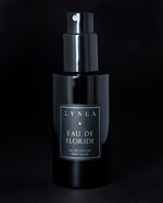 100ml black glass bottle of LVNEA’s Eau de Floride natural fragrance on black background