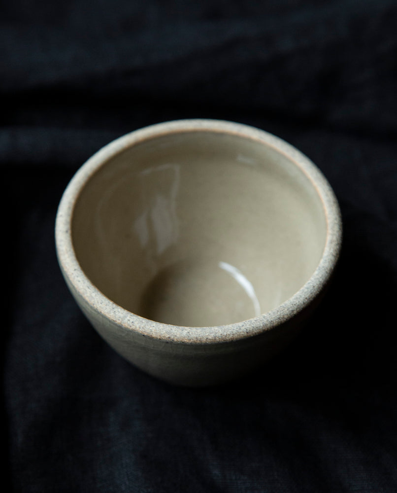 clay-coloured stoneware bowl on black background