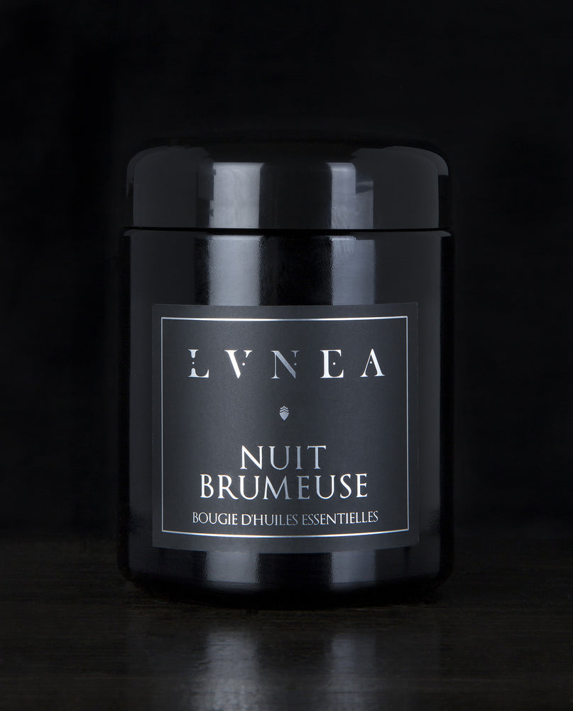 LVNEA’s Nuit Brumeuse candle housed in a resealable 8 ounce black glass jar on a black background