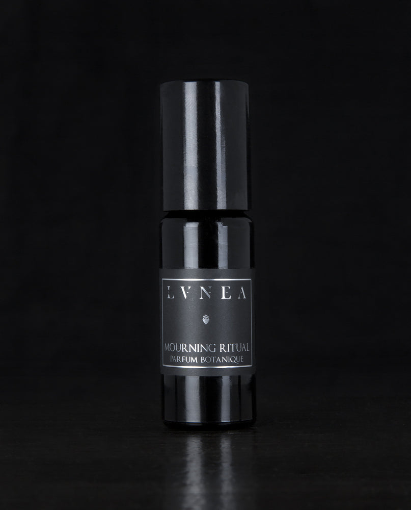 10ml black glass bottle of LVNEA's Mourning Ritual natural roll on perfume oil on black background