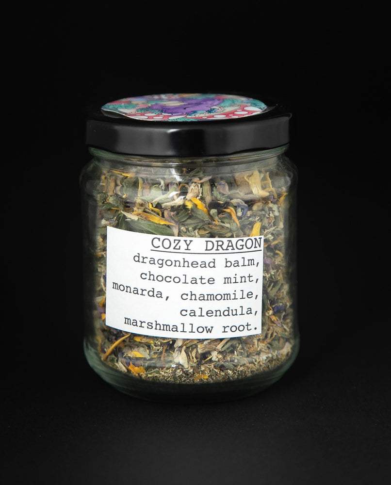 clear glass jar with black lid of blueberryjams' "Cozy Dragon" herbal tea blend