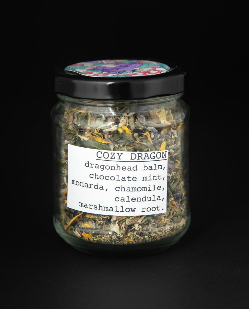 clear glass jar with black lid of blueberryjams' "Cozy Dragon" herbal tea blend